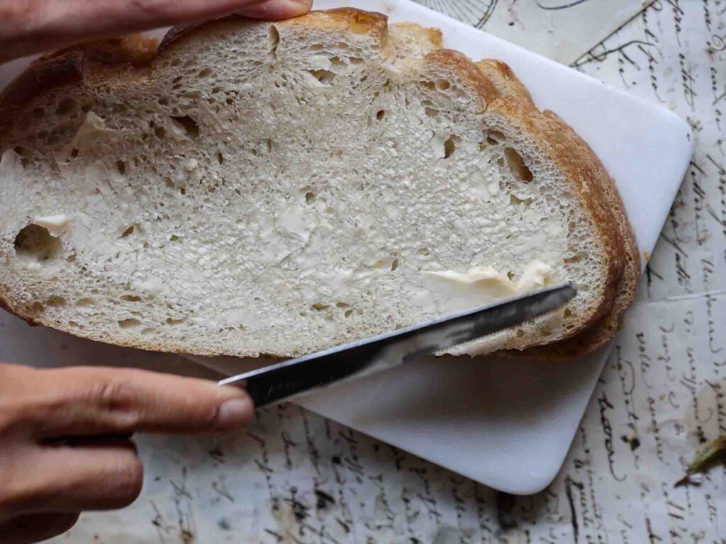 buttering sourdough bread for vegan grilled cheese